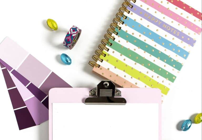 Clip board with colorful objects around it