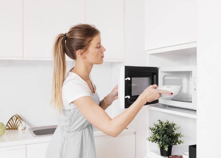 Women putting bowl in microwave
