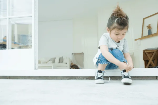 child putting their shoes on independently