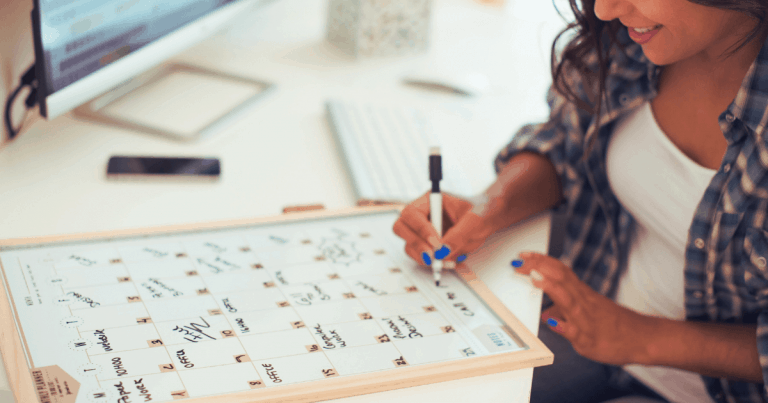 Women writing on erasable calendar