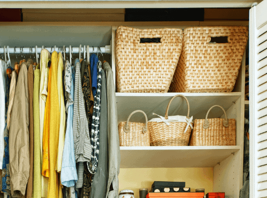 Closet with baskets and hanging clothes