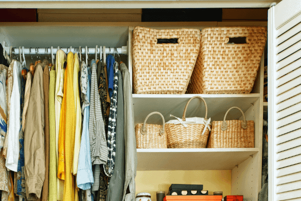 Closet with baskets and hanging clothes