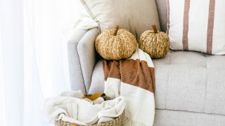 Picture of a cream couch with wicker pumpkins and a wicker basket