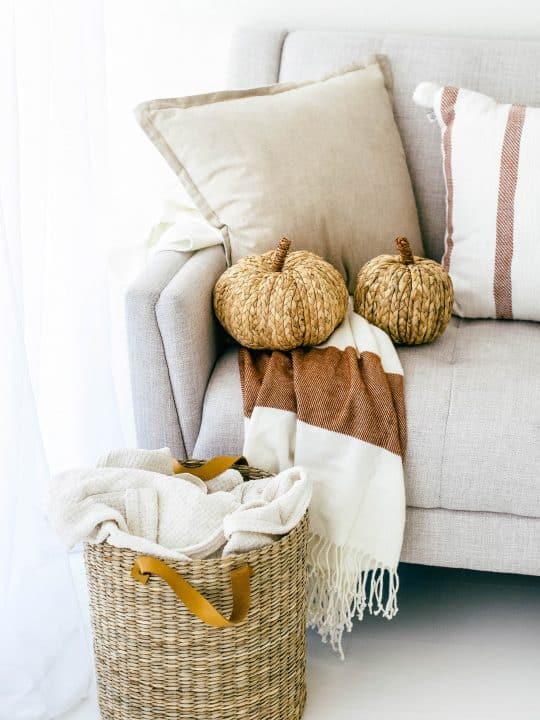 Picture of a cream couch with wicker pumpkins and a wicker basket