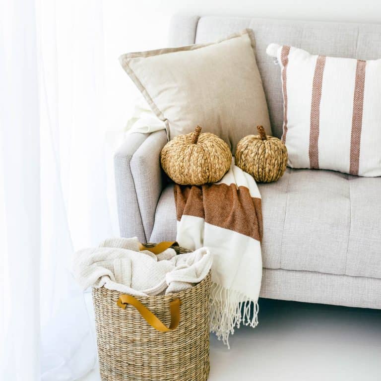 Picture of a cream couch with wicker pumpkins and a wicker basket