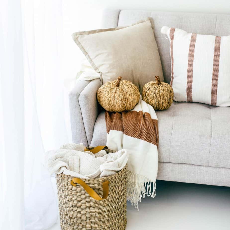 Picture of a cream couch with wicker pumpkins and a wicker basket