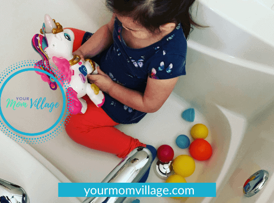 Toddler playing with toys in bath tub