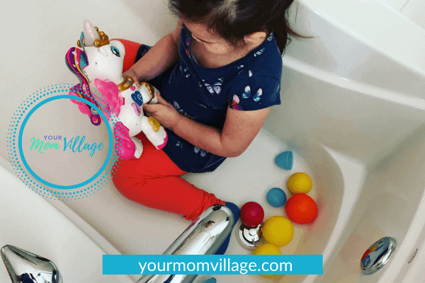 Toddler playing with toys in bath tub