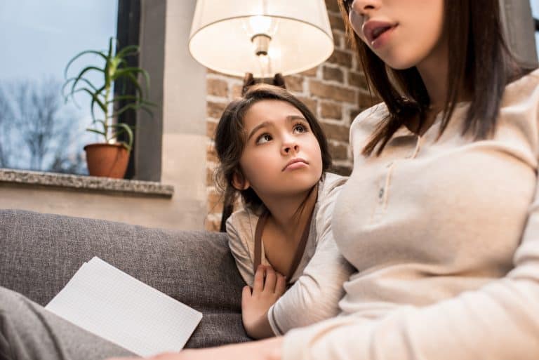 Sad kid with mom reading