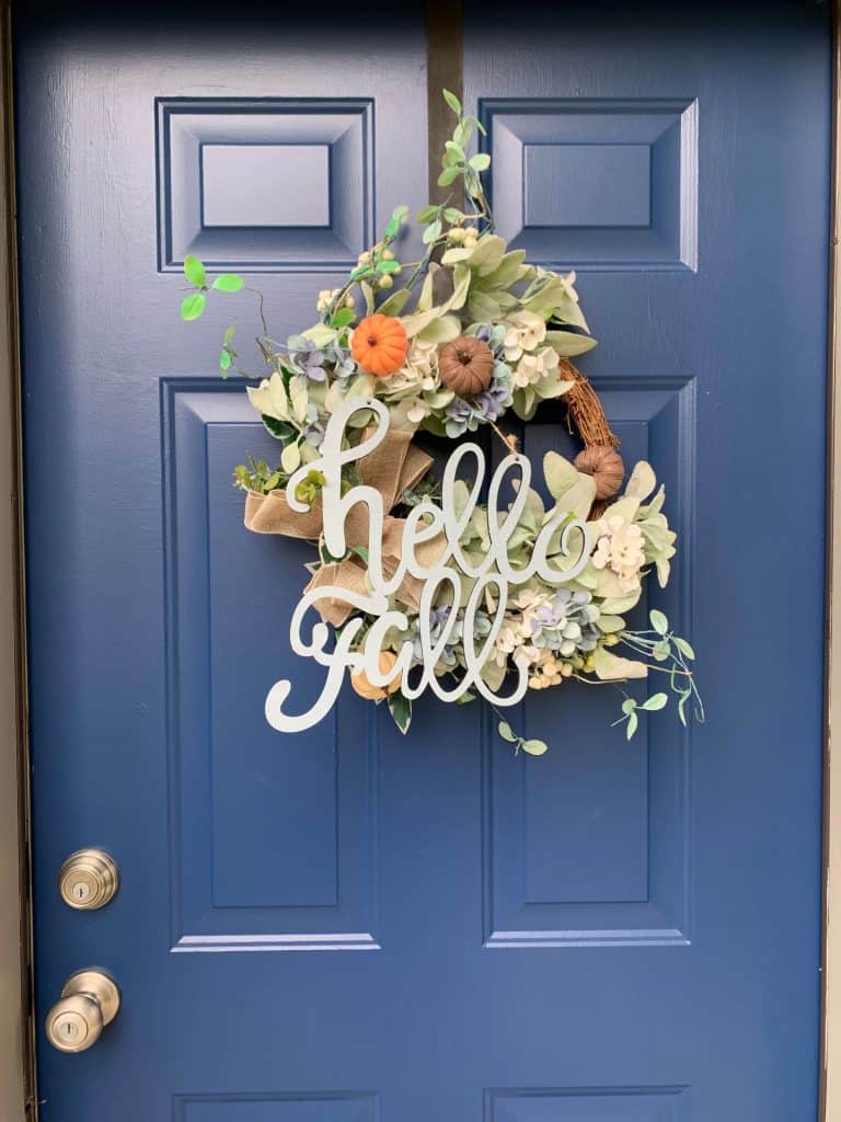 Blue front door and post about indoor and outdoor fall cleaning checklist