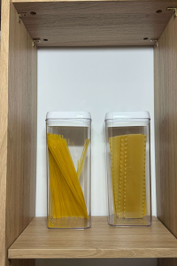 Pasta stored in clear containers in pantry